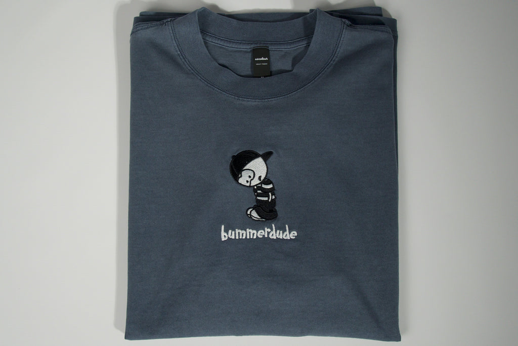Folded blue t-shirt with a graphic design and text on a gray background